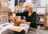 Ceramista feminina usando argila e criando barro artesanal no estúdio de arte — Fotografia de Stock
