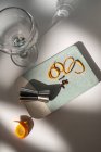 Зверху склянки біля металевого цигана з цитрусовою плодовою цедрою і сухими приправами на столі з тінями — стокове фото