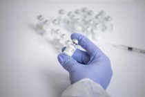 Manos de una doctora irreconocible sosteniendo un vial de vacuna contra el coronavirus - foto de stock