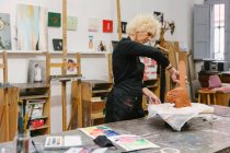 Ceramista femenina usando arcilla y creando barro artesanal en estudio de arte - foto de stock