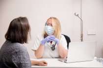 Female doctor attending a patient in her medical office — Stock Photo