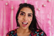 Mädchen in rosafarbenen Farben schaut mit überraschtem Gesichtsausdruck in die Kamera — Stockfoto