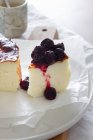 Délicieuses tranches de gâteau au fromage cuit garni de confiture de baies servi sur une assiette — Photo de stock