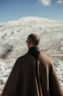 Blick zurück auf anonyme männliche Touristen im Kap, die den schneebedeckten Berg unter blauem wolkenverhangenem Himmel im Winter bewundern — Stockfoto