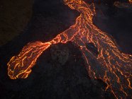 Von oben fließt das Magma des Vulkans in Form von Lavaflüssen über den Boden in Island — Stockfoto