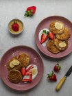 Top view plate with banana pancakes and a few pieces of strawberries — Stock Photo