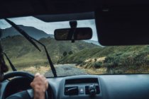 Recorte anónimo vehículo conductor masculino en ruta en majestuosas montañas de los Pirineos durante la lluvia - foto de stock