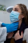 Unbekannter Mediziner in Handschuhen untersucht Lymphknoten einer Patientin bei Termin in modernem Krankenhaus — Stockfoto
