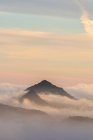 Paisagem de tirar o fôlego de picos de montanha cobertos com nuvens sob o colorido céu do pôr-do-sol no Parque Nacional Sierra de Guadarrama — Fotografia de Stock