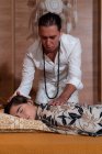 Maschio terapeuta spirituale strofinando le mani e toccando rilassato testa femminile con la schiena durante la terapia alternativa — Foto stock
