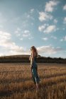 Tranquillo femminile in abito elegante in piedi sul campo asciutto in zona rurale e guardando la fotocamera — Foto stock