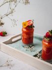 Nahaufnahme eines leckeren Erdbeer-Smoothies mit gelber Blütengarnitur — Stockfoto