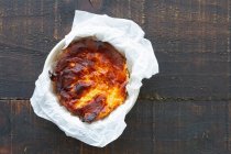 Dall'alto deliziosa torta di formaggio al forno servita su un contenitore in un tavolo di legno — Foto stock