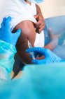 Beschnitten bis zur Unkenntlichkeit weibliche Fachärztin in Schutzuniform, Latexhandschuhen und Gesichtsmaske Impfung afroamerikanischer Mann Patient in Klinik während Coronavirus-Ausbruch — Stockfoto
