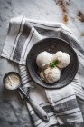 Top view of tasty gelato with fresh mint leaves and cinnamon powder on top near scooper on towel — Stock Photo