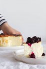 Deliciosas rebanadas de pastel de queso al horno rematadas con mermelada de bayas servidas en un plato - foto de stock