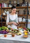 Weibchen mit frischer Rote Bete in einer Schüssel bereitet vegetarisches Salatessen in der Hausküche zu — Stockfoto