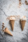 Overhead view of tasty waffle cones with creamy meringue milk gelato scoops on marble table — Stock Photo