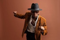 Junger afroamerikanischer Mann in trendiger Kleidung und Hut tanzt in die Kamera — Stockfoto