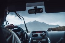 Crop veículo de condução masculino anônimo na rota em majestosas montanhas dos Pirenéus durante a chuva — Fotografia de Stock