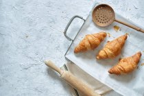 Draufsicht auf leckere frische Croissants auf Metalltablett auf dem Tisch in der Küche — Stockfoto