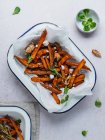 Hoher Winkel von leckeren Süßkartoffelfrites mit saurer Sahne und Kräutern auf dem Tisch serviert — Stockfoto