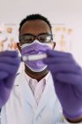 Africano americano médico masculino na luva médica demonstrando tubo de teste com amostra de sangue no fundo branco — Fotografia de Stock