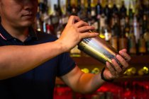 Barman trabalhando com agitador para misturar um coquetel no bar — Fotografia de Stock