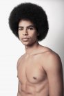 Jovem negro confiante com seis abdominais pack e penteado afro olhando para a câmera no fundo branco — Fotografia de Stock