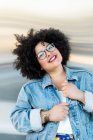 Erwachsene übergewichtige Frau in trendiger Kleidung und Brille mit Afro-Frisur blickt in die Kamera auf verschwommenem Hintergrund — Stockfoto