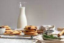 Delicious homemade sweet cookies with chocolate ships served on tray with glass jar of milk — Stock Photo