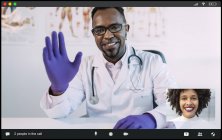 Médico masculino afro-americano positivo em uniforme médico e luvas acenando a mão e sorrindo enquanto saúda paciente feminina étnica durante videoconferência — Fotografia de Stock