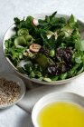 Вид зверху на свіжий здоровий овочевий салат у мисці, який подається на столі з оливковою олією та насінням соняшнику — стокове фото