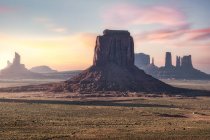 Дивовижний краєвид високих скелястих утворень, розташованих у Долині монументів в Америці під яскравим небом під час заходу сонця. — стокове фото