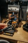 Cultivar barista irreconhecível usando moedor de café enquanto prepara café fresco aromático no café durante o dia — Fotografia de Stock