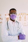 Médecin professionnel afro-américain avec stéthoscope en uniforme et lunettes regardant la caméra à l'hôpital — Photo de stock