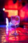 Cóctel gin tonic bien elaborado decorado con fresas y tobogán de limón seco en el bar - foto de stock