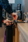 Crop barista senza volto in piedi a tavola e preparare caffè aromatico fresco mentre si lavora in mensa durante il giorno — Foto stock