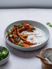 High angle of delicious sweet potato fries with sour cream and herbs served on table — Stock Photo