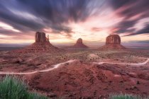 Spettacolare scenario di alte formazioni rocciose situate nella Monument Valley in America sotto il cielo colorato al tramonto — Foto stock