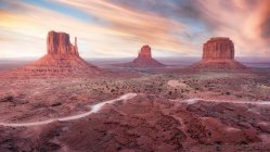 Spettacolare scenario di alte formazioni rocciose situate nella Monument Valley in America sotto il cielo colorato al tramonto — Foto stock