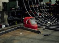 Mesa de metal con máscara de soldadura cerca de bobina de papelería con alambre eléctrico en garaje profesional - foto de stock