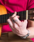Crop-Musiker in Freizeitkleidung spielt tagsüber in hellem Raum zu Hause Gitarre — Stockfoto