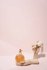 Élégante bouteille transparente de parfum placée entre les mains en bois placées sur fond rose dans un studio lumineux — Photo de stock