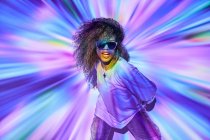 Elegante confiante dançarina afro-americana com cabelo encaracolado em óculos de sol de pé em luzes de néon no estúdio de dança — Fotografia de Stock