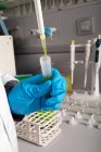 Анонимный химик выращивает марихуану из пипетки в пробирку во время обследования в лаборатории — стоковое фото