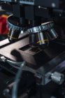 Modernes professionelles Mikroskop mit leistungsstarken Linsen auf dem Tisch im modern ausgestatteten Labor — Stockfoto