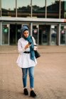 Muslim woman browsing smartphone near train station — Stock Photo