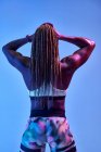 Vista posteriore di anonima atleta afro-americana muscolare con corpo sudato che mostra bicipiti su sfondo blu — Foto stock