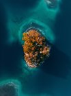 From above breathtaking aerial view of island in calm lake with turquoise water located in highlands — Stock Photo